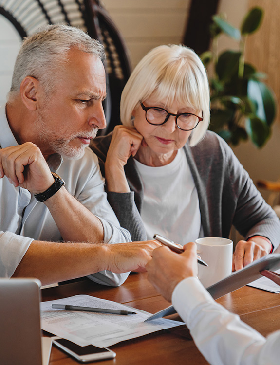 senior couple at financial review with wealth management advisor